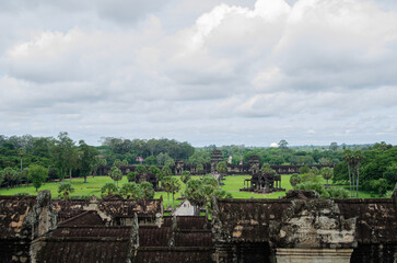 Fototapeta na wymiar Ancient Buddhist Temple Ruins of Angkor Wat in Siem Reap, Cambodia. Green Lands And Forest View From The Monuments.