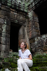 Fototapeta na wymiar Caucasian Tourist Woman Enjoying and Relaxing The Temples Of Angkor Wat In Cambodia