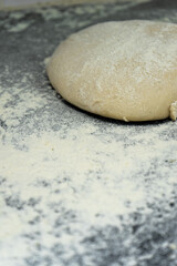Fresh pizza dough balls on a rustic countertop at a pizzeria, ready for rolling and shaping.
