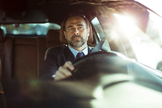 Focused businessman drives his car in the morning light