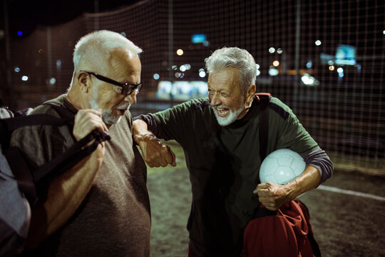 Elderly friends sharing a light moment after a soccer game
