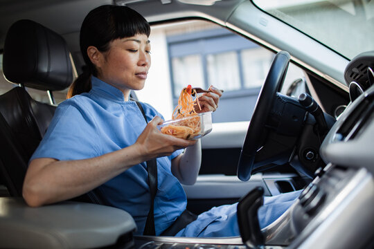 Nurse enjoying a meal in her car during a break