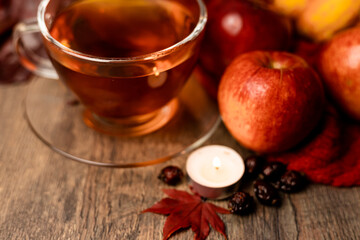 Cup of tea, candle, autumn fruits on the table. Autumn Evening Mood