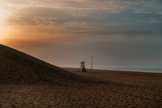 lifeguard tower on maspalomas beach at sunrise.