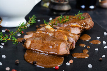 Grilled beef steak with herbs and spices on stone plate