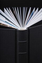 A beautiful leather bound books against a black background. Wedding photo book, family album....