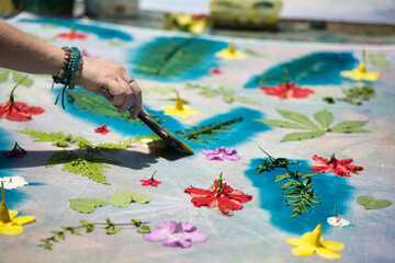 Obraz premium White skin woman, painting over leaves with cloth printing ink at workshop for her pareo making, Mahe Seychelles 5