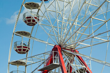 Ferris wheel in an amusement park against a blue sky