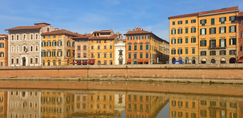 The street of Pisa is reflected in the river Arno. Panorama.