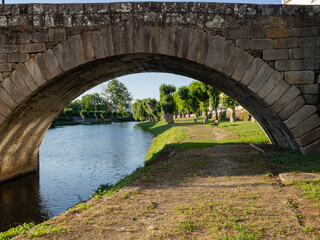 Paisaje verde con río azul, visto desde el arco de un puente antiguo en Monforte de Lemos, paseando por Galicia, España, en verano de 2021.