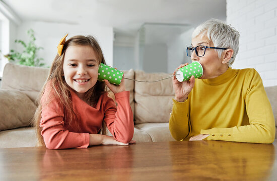 grandchild family child grandparent grandmother game playing granddaughter phone toy communication connection call string talk cup telephone voice message technology sound listen wire girl hobby