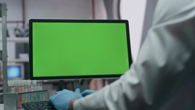 Gloves hands typing keyboard green screen computer in laboratory close up.