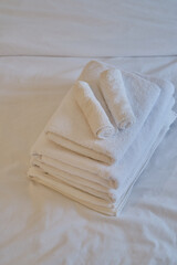 A stack of clean white towels in bathroom. Hotel service. Place for text
