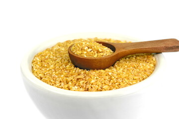 Raw Bulgur in a bowl Isolated on a white background. Raw bulghur, dry cracked parboiled wheat groats, cereal 