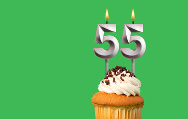 Birthday with number 55 candle and cupcake - Anniversary card on green color background