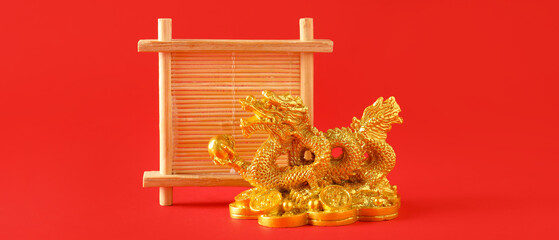 Golden figurine of Chinese dragon and wooden decor on red background