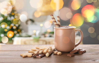 Cup of hot chocolate and sweets on table in room