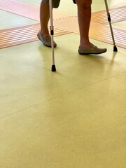 Legs in person with crutches on yellow floor