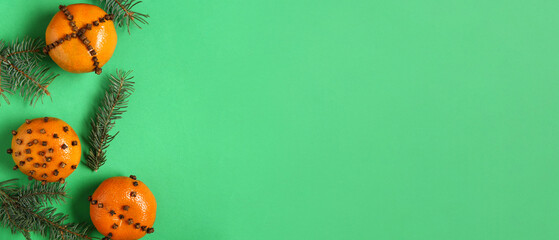 Pomander balls and Christmas tree branches on green background with space for text