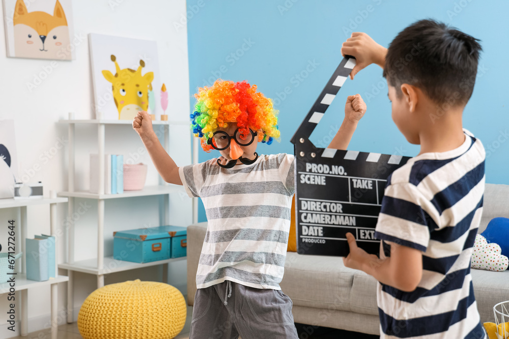 Sticker Cute little boys playing with movie clapper at home