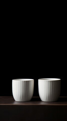 Two white cups sitting on top of a table