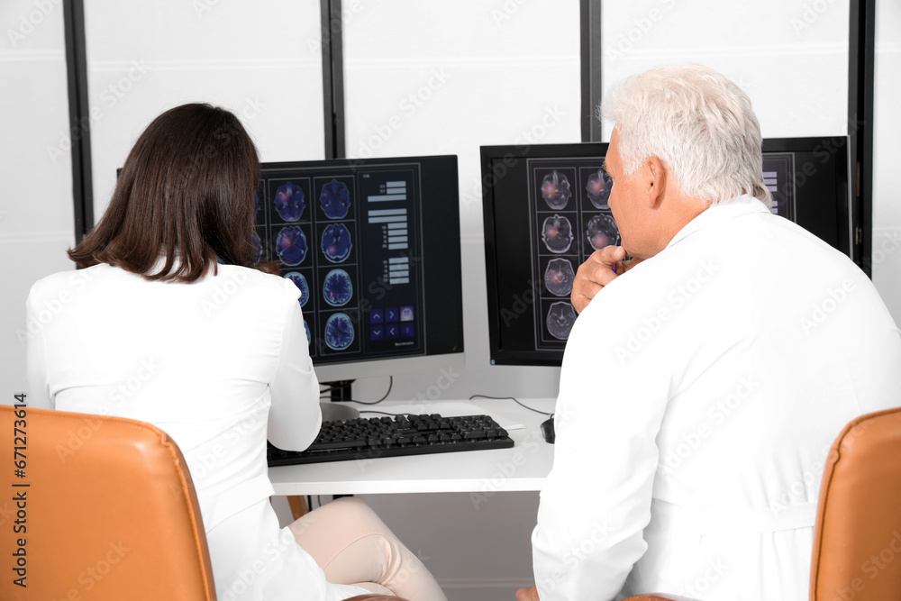 Poster doctors discussing x-ray image on computer in medical office