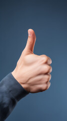 A person's hand giving a thumbs up sign