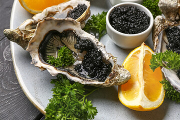 Plate of tasty oysters with lemon and black caviar on table - obrazy, fototapety, plakaty