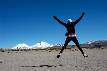 young woman with her back jumping when she sees volcano