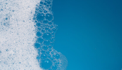 Detergent foam bubble on water. Blue background, Soap sud