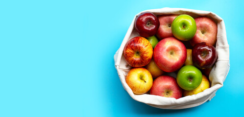 Variety of fresh apples on blue background.