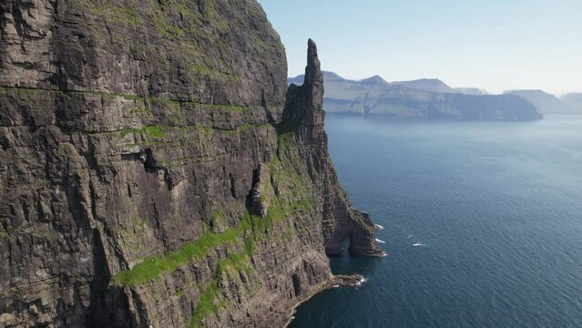 FAROE ISLANDS - JULY.16.2023 - Excellent aerial footage passing over the Trollkonufingur, or Troll Finger, monolith on the Faroe Islands.