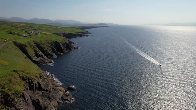 IRELAND- 8.27.2023 -Excellent aerial footage over a boat traveling along the coast of Dingle, Ireland.