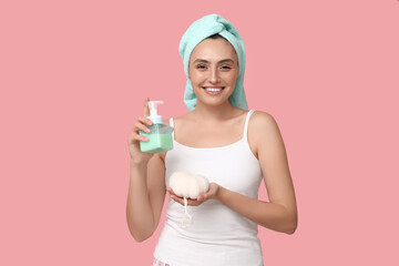 Young woman with shower gel and loofah on pink background