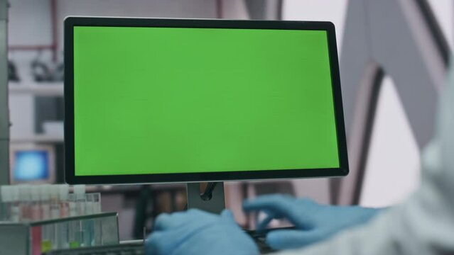 Doctor typing green screen computer in modern advanced laboratory close up.