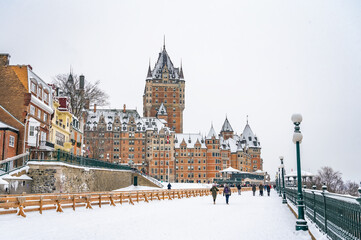 Dufferin Terrace, a long wooden sidewalk next to the historic Fairmont Chateau Frontenac hotel, giant tobogganing run in the winter on a snowy day, Quebec City, Canada. Photo taken in December 2022. - obrazy, fototapety, plakaty