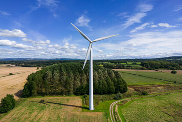 Aerial mid-level image of a small rural wind farm with wind turbines in the English countryside