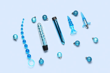 Composition with sex toys and Christmas balls on blue background