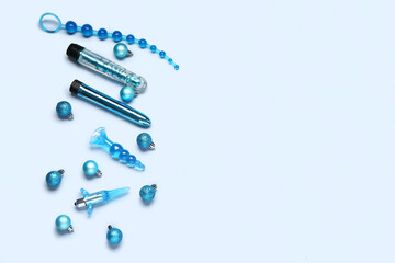 Composition with sex toys and Christmas balls on blue background