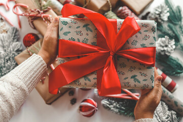 Christmas gift with red bow in hands