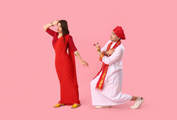 Young Indian woman rejecting marriage proposal on pink background - obrazy, fototapety, plakaty