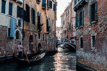 Fototapeta premium Scenic canal with bridge and old buildings with potted plants in Venice, Italy