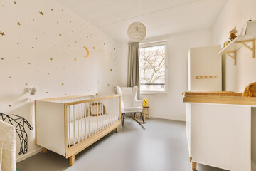 Nursery with crib and chair by star wallpaper