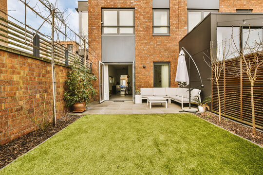 Building with furniture and grassy lawn in yard