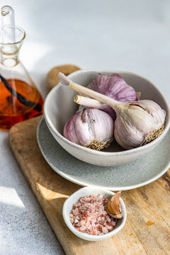 Garlic bulbs on wooden board with salt