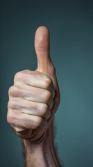 A man's hand giving a thumbs up sign