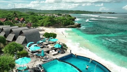 INDONESIA - AUGUST.9.2023 - Excellent aerial footage moving over tourists enjoying the surf on Dream Beach in Nusa Lembongan, Indonesia. - Powered by Adobe