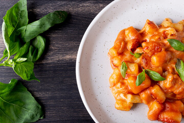 Gnocchi with tomato sauce, mozzarella cheese and basil. Italian traditional food.