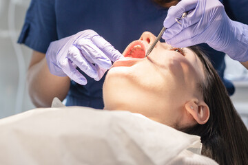 The dentist cleans the patient's mouth.