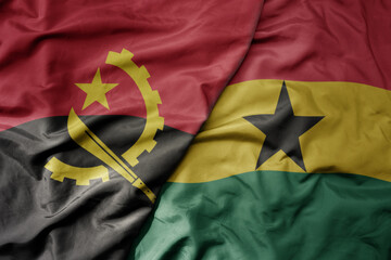 big waving national colorful flag of angola and national flag of ghana .